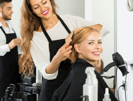 Hairdresser combing clients hair